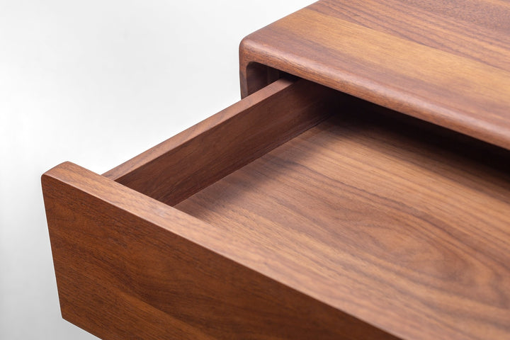 Macro close-up of Frank Nightstand open drawer interior showing rich walnut grain texture,  and solid wood sides