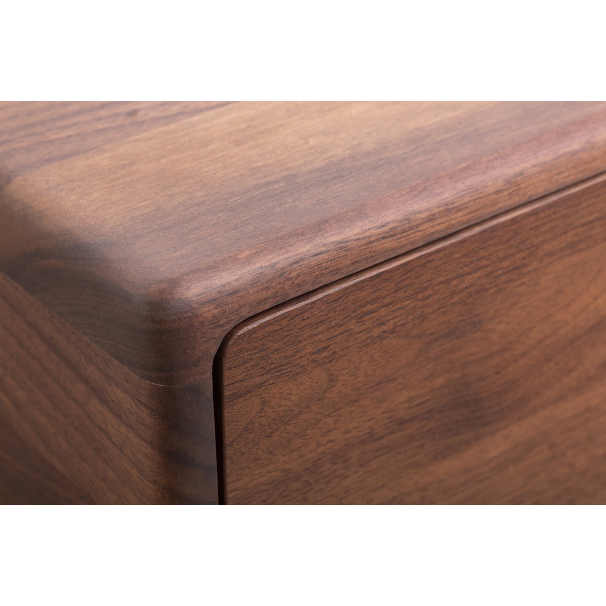 Macro close-up of Frank Walnut Nightstand top corner showing softly rounded edge, seamless matte lacquer finish